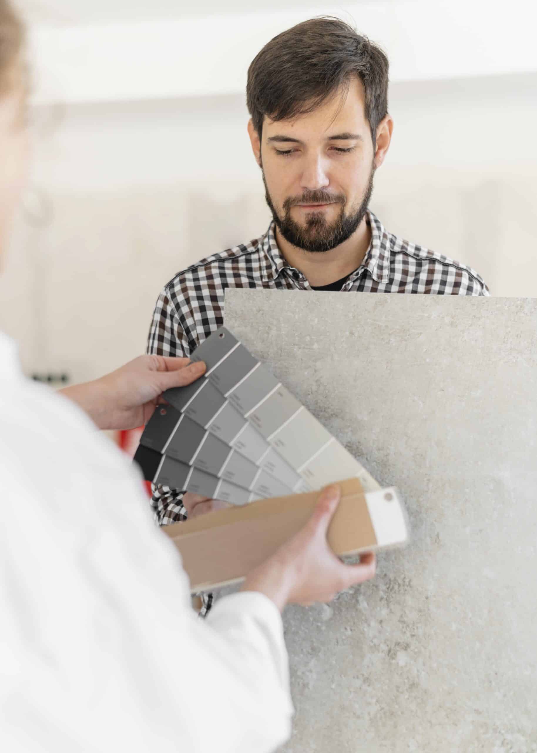 Designer showing color swatches and material samples to a homeowner during a color consultation.