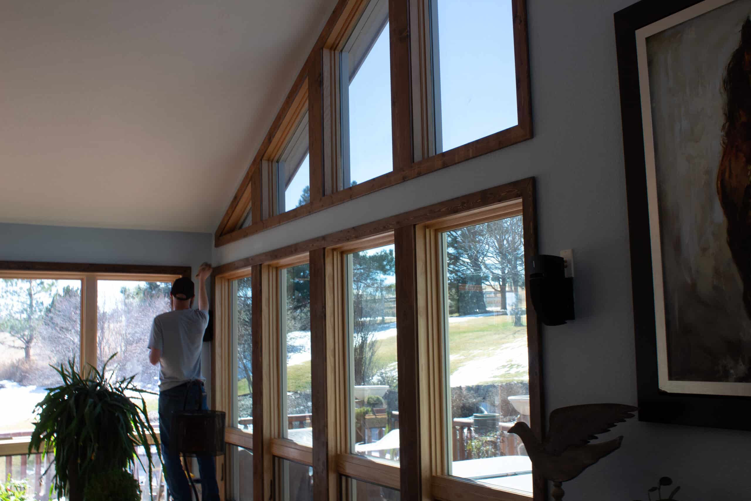 Professional trim carpentry and custom millwork detailing on large windows in a Front Range interior home remodel.