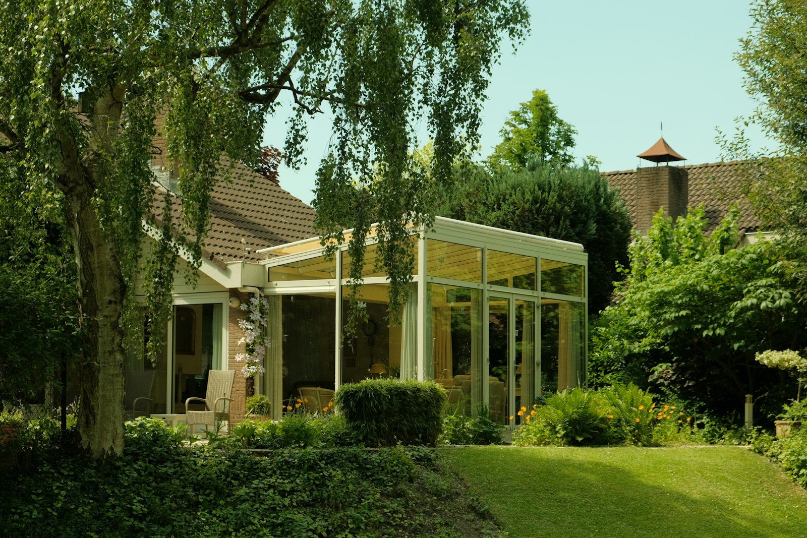 Modern sunroom addition attached to a house surrounded by trees